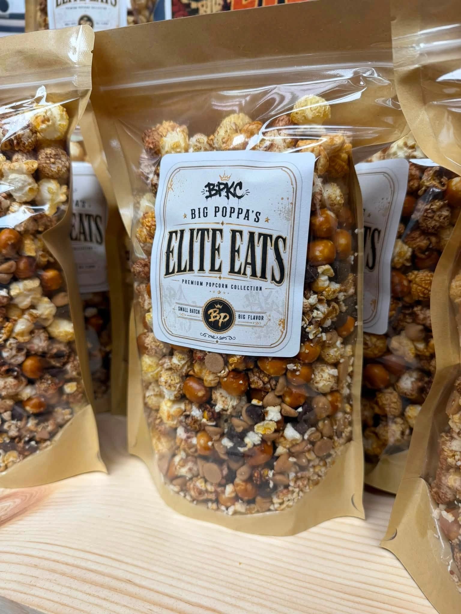 Big Poppa's Elite Eats premium popcorn collection in kraft bags with black-and-gold labels