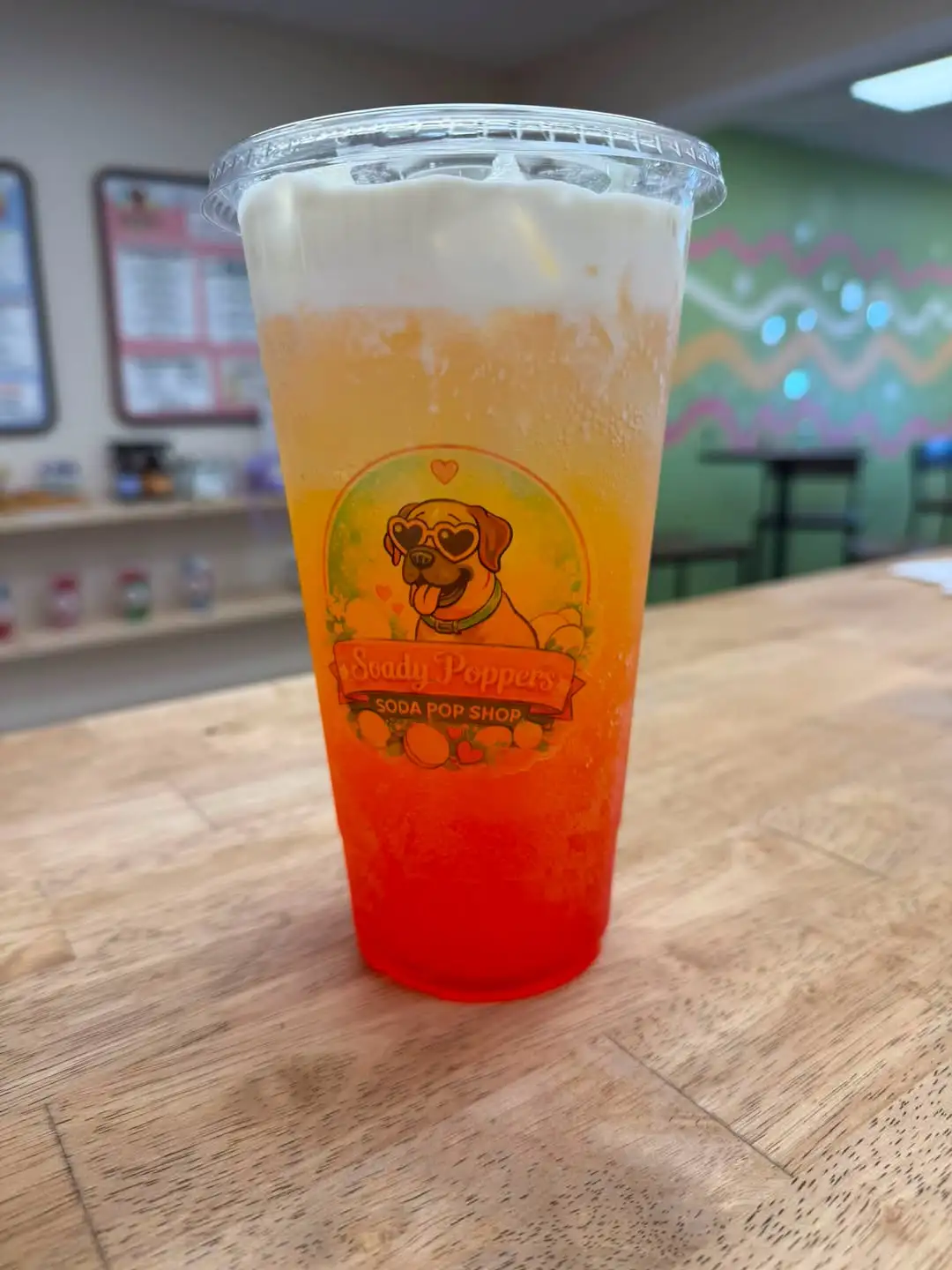 A Soady Poppers layered lemonade in a logo cup